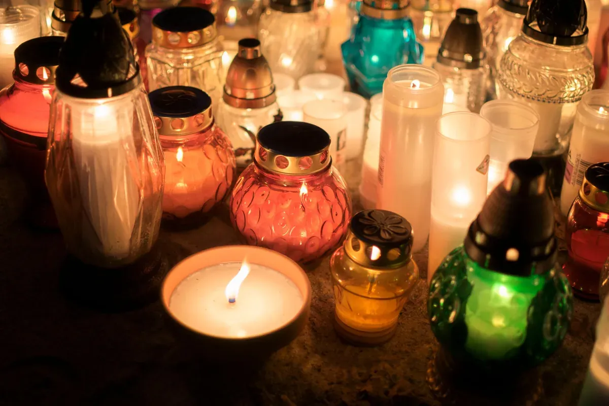 Votive candles glowing at an outdoor memorial